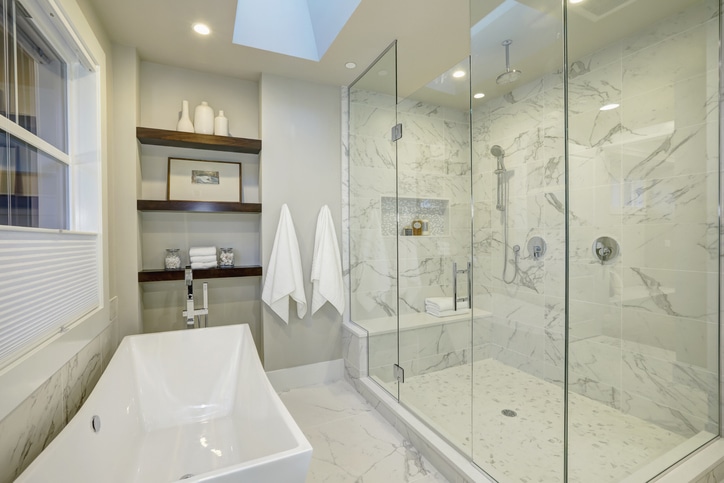 Amazing white and gray marble bath room with large glass walk-in shower, freestanding tub and skylights on the ceiling